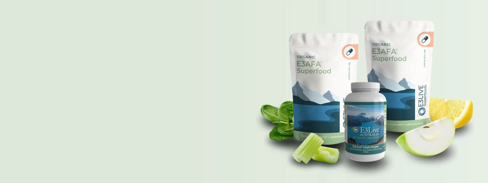 E3AFA/E3Live Collection - Features a green textured background with vibrant ingredients on the right side, including fresh spinach leaves, green apples, a glass jar of green smoothie, a bowl of green E3AFA powder, and green E3AFA capsules.