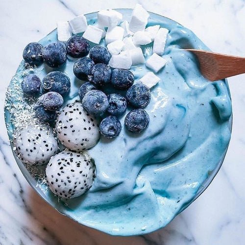 BlueMAJIK Ocean Inspired Smoothie Bowl topped with fresh blueberries, coconut flakes, and cubed coconut, showcasing a vibrant blue smoothie made from BlueMAJIK for a nutritious and colourful treat.