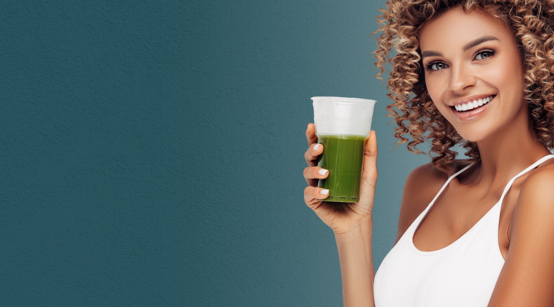 Smiling woman holding a green superfood drink, representing a wide range of E3Live Superfoods products focused on health, energy, and wellness.